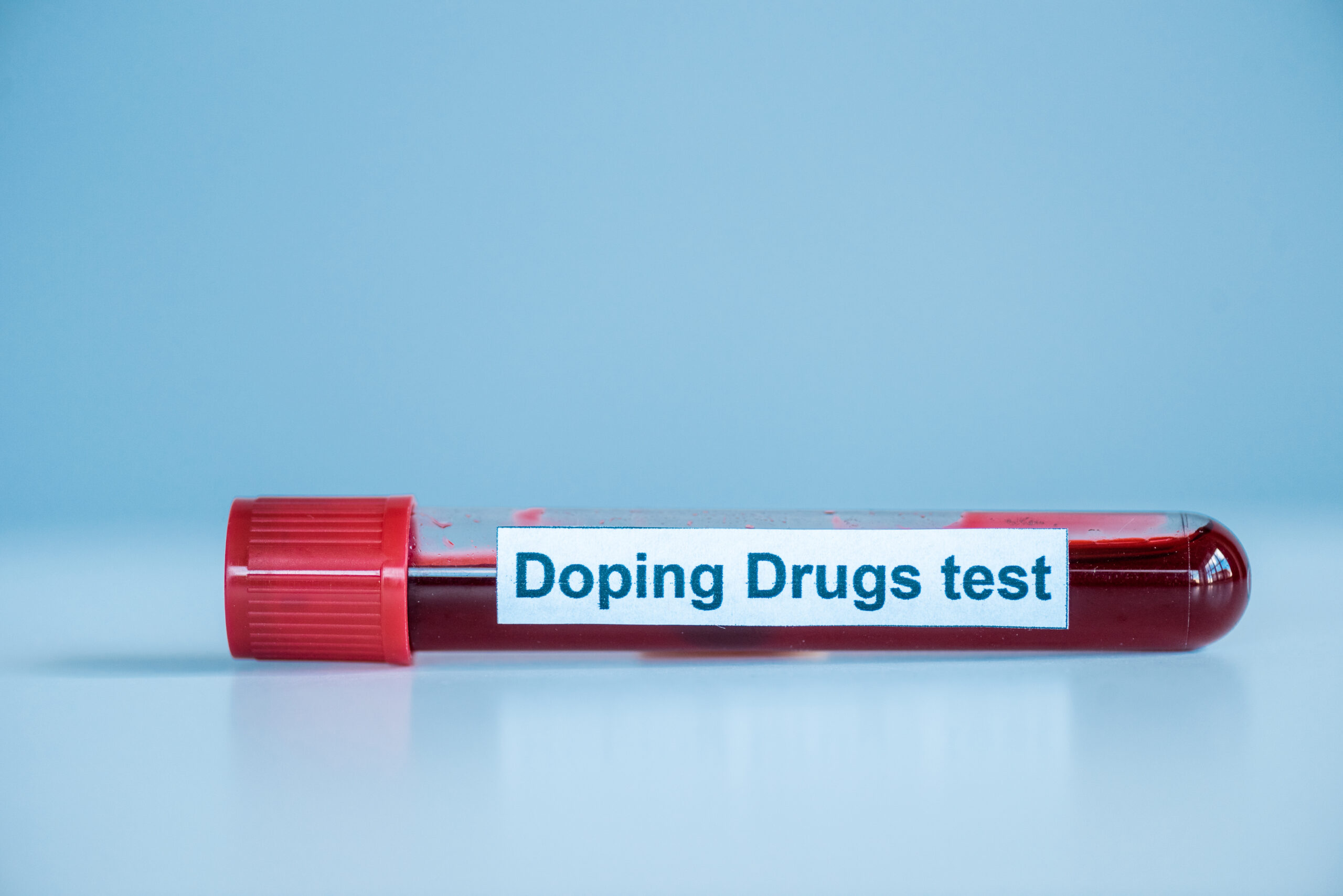 test tube with sample and doping drugs test lettering on blue
